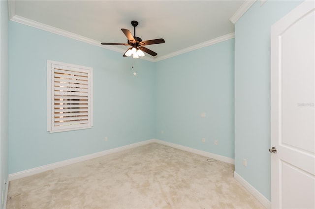 carpeted empty room featuring baseboards, ornamental molding, and a ceiling fan