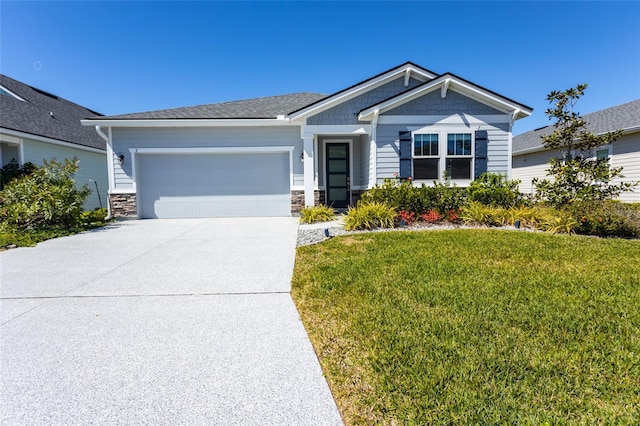 view of front of home featuring stone siding, a garage, driveway, and a front yard