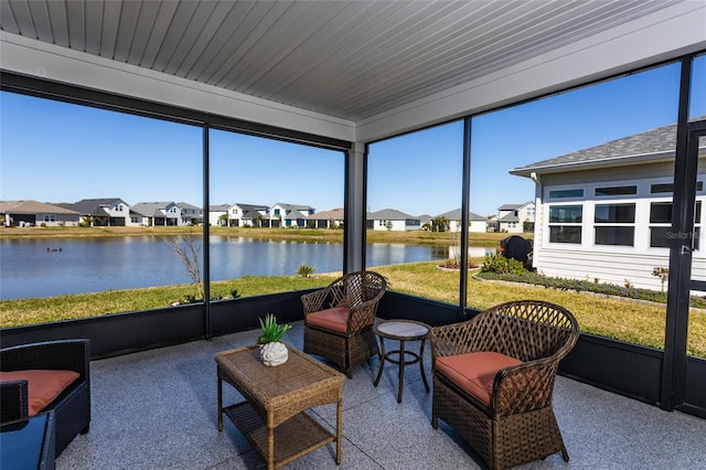 sunroom with a residential view and a water view