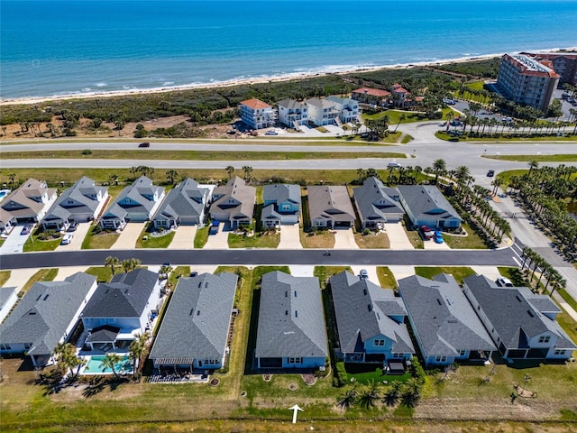 drone / aerial view with a residential view, a beach view, and a water view