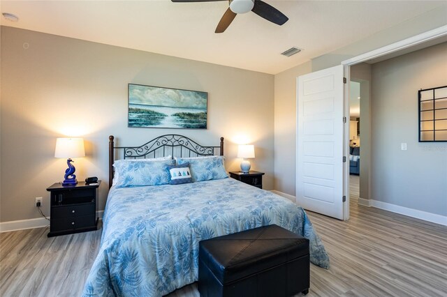 bedroom with visible vents, baseboards, and wood finished floors