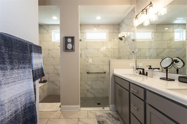 full bath with a healthy amount of sunlight, marble finish floor, a walk in shower, and a sink