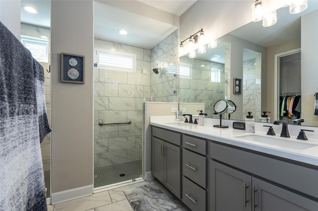 bathroom with a sink, marble finish floor, and a healthy amount of sunlight