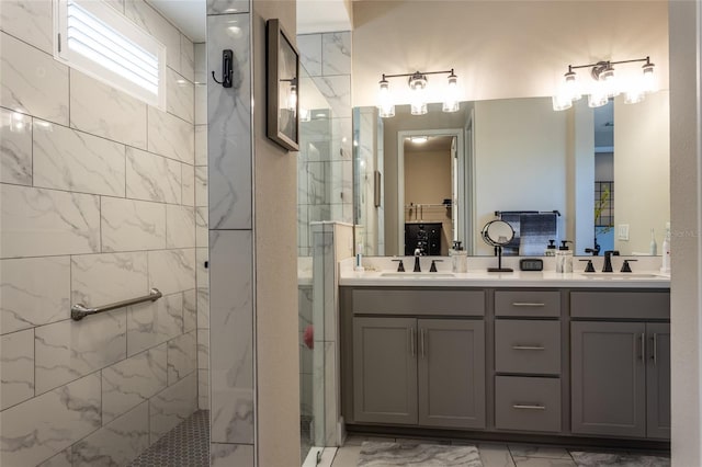 bathroom with a sink, marble finish floor, and a tile shower