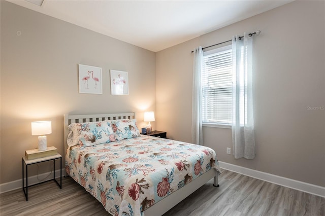 bedroom featuring baseboards and wood finished floors