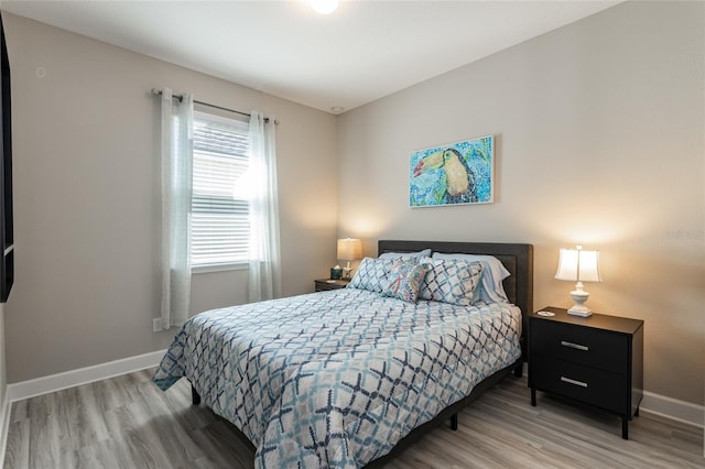 bedroom featuring baseboards and light wood-style floors