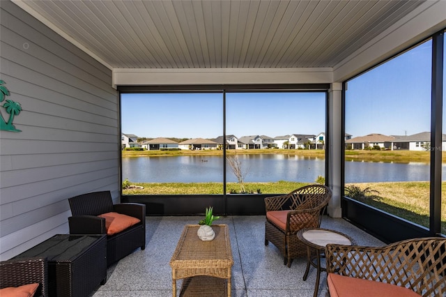 sunroom featuring a residential view, wood ceiling, and a water view