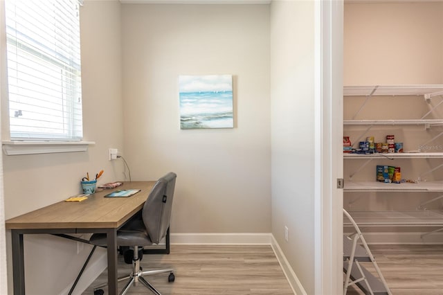 office area with light wood-style flooring and baseboards