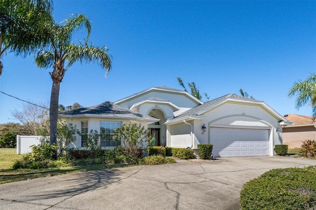 single story home featuring stucco siding, a garage, driveway, and fence