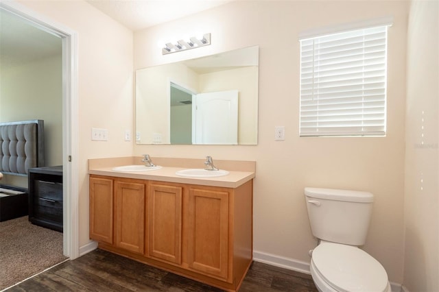 bathroom featuring toilet, wood finished floors, and a sink