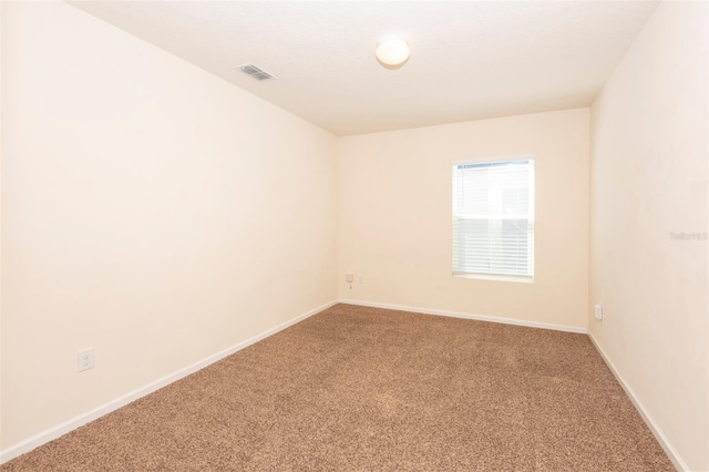 carpeted empty room with visible vents and baseboards