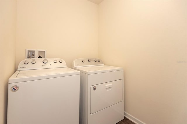 laundry room with baseboards, separate washer and dryer, and laundry area