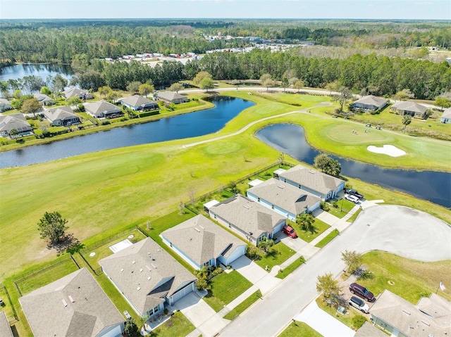 drone / aerial view featuring golf course view, a water view, and a residential view