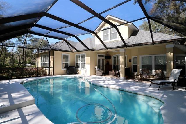 pool featuring glass enclosure and a patio area