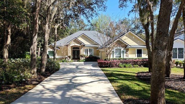 view of front of property featuring stucco siding, concrete driveway, and a front yard