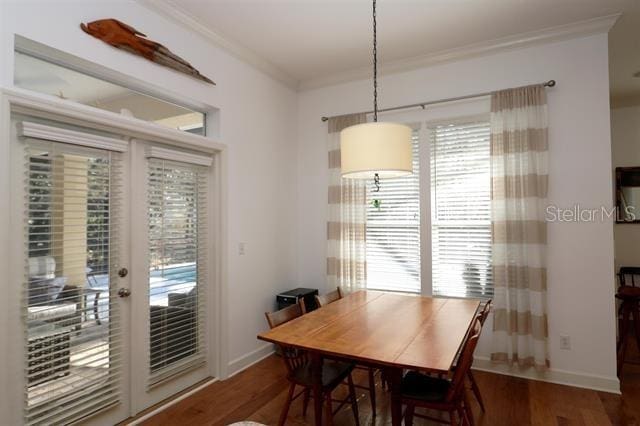 dining space featuring crown molding, wood finished floors, baseboards, and french doors