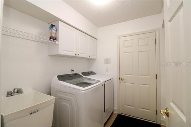 laundry area with a sink, cabinet space, and washing machine and clothes dryer