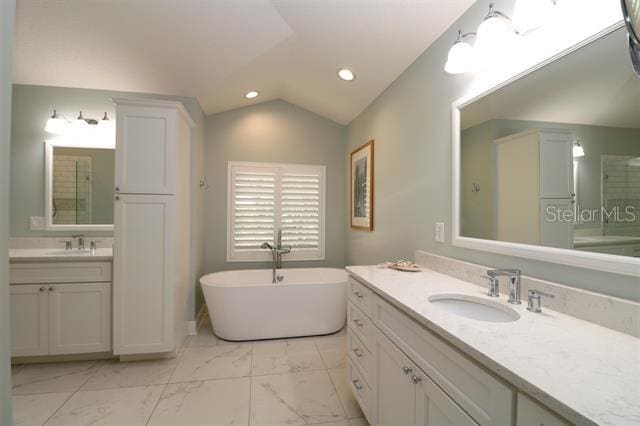 full bath with recessed lighting, marble finish floor, lofted ceiling, and a sink