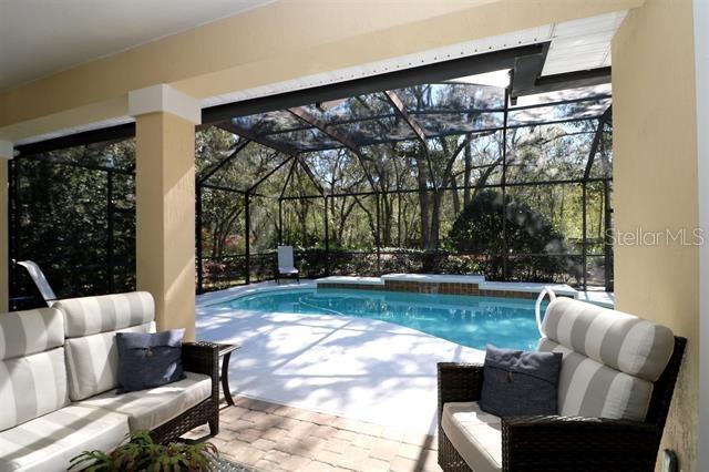 outdoor pool featuring a patio area, an outdoor hangout area, and a lanai