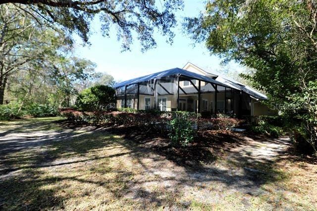 rear view of property featuring a lanai