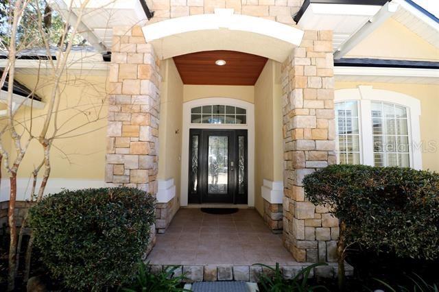 doorway to property featuring stucco siding and stone siding