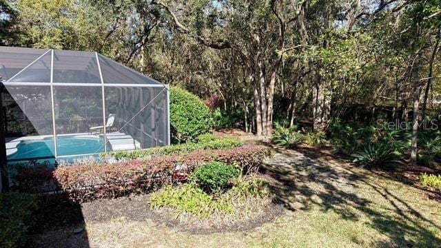 view of yard featuring an outdoor pool and glass enclosure