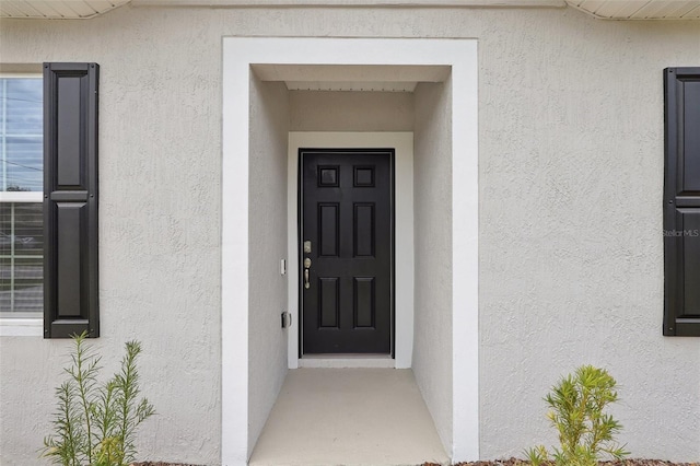 property entrance with stucco siding