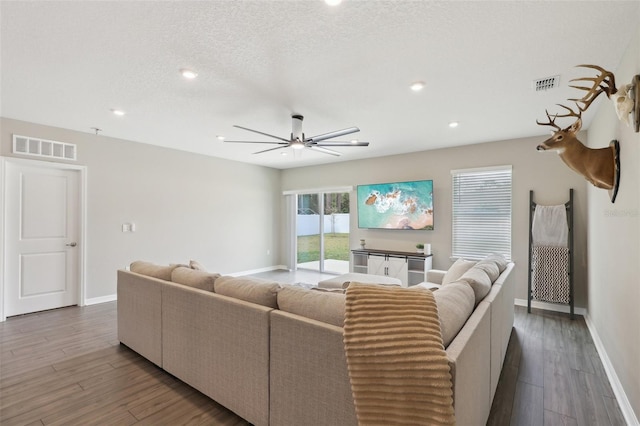 living room featuring visible vents, baseboards, and wood finished floors