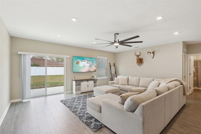 living area with a ceiling fan, recessed lighting, wood finished floors, and baseboards