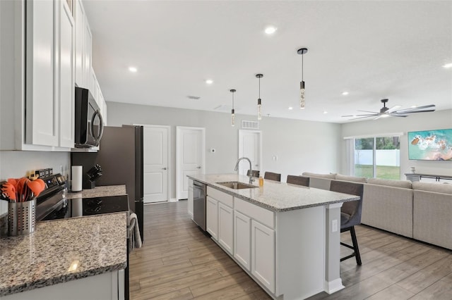 kitchen featuring a breakfast bar, white cabinets, and stainless steel appliances