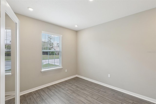 empty room with recessed lighting, baseboards, and wood finished floors