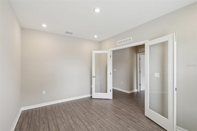 unfurnished bedroom featuring visible vents, french doors, and wood finished floors