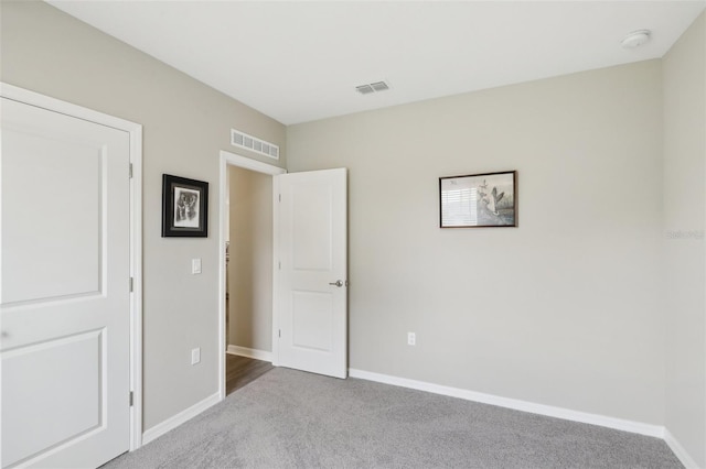 unfurnished bedroom with visible vents, baseboards, and carpet flooring