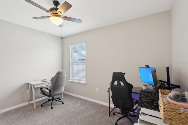 office space with a ceiling fan, baseboards, carpet floors, and a textured ceiling