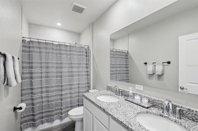 full bath featuring double vanity, toilet, visible vents, and a sink