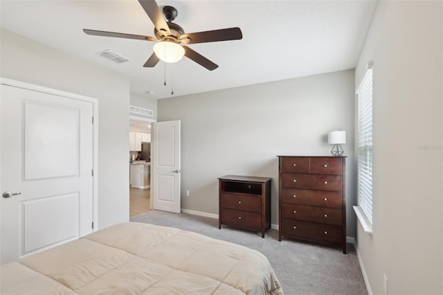 bedroom featuring baseboards, visible vents, and light carpet