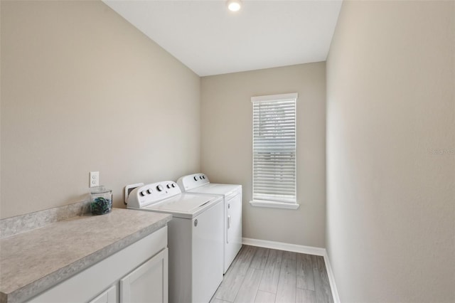 laundry room with baseboards, light wood-style floors, and washing machine and clothes dryer