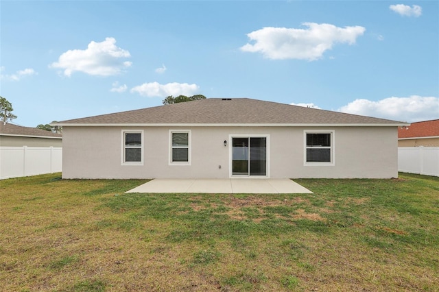 rear view of house featuring a patio, a yard, a fenced backyard, and stucco siding