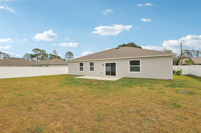 rear view of house with a patio, a lawn, a fenced backyard, and stucco siding