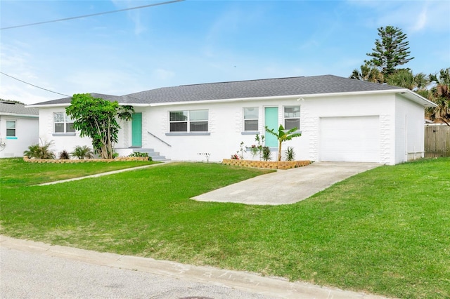 ranch-style home with an attached garage, concrete driveway, a front lawn, and a shingled roof