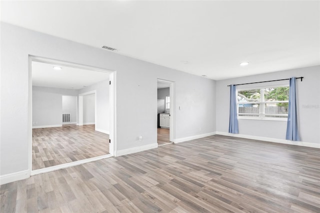 empty room with visible vents, recessed lighting, baseboards, and wood finished floors