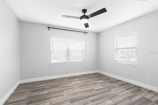 unfurnished room with wood finished floors, baseboards, and a wealth of natural light