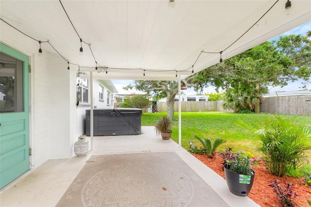 view of patio with a fenced backyard and a hot tub