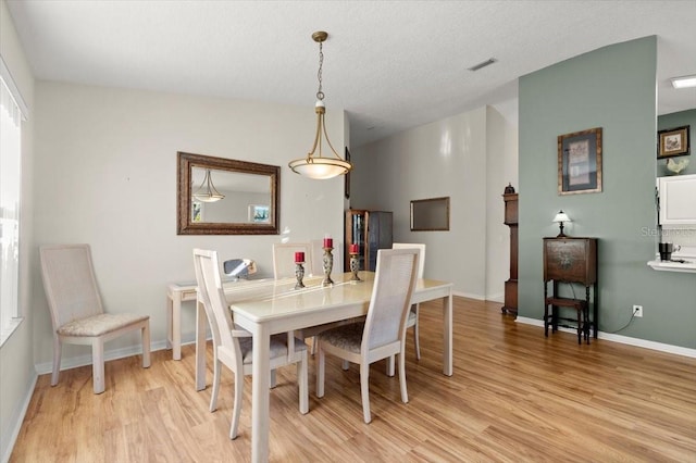 dining space with visible vents, baseboards, and light wood-style floors