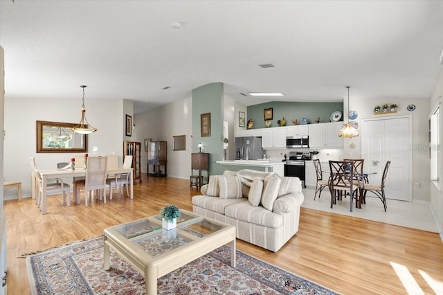 living room with light wood-type flooring and vaulted ceiling