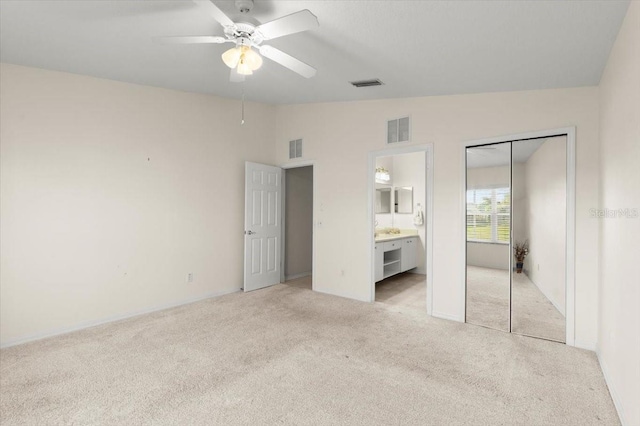 unfurnished bedroom with visible vents, lofted ceiling, and light colored carpet