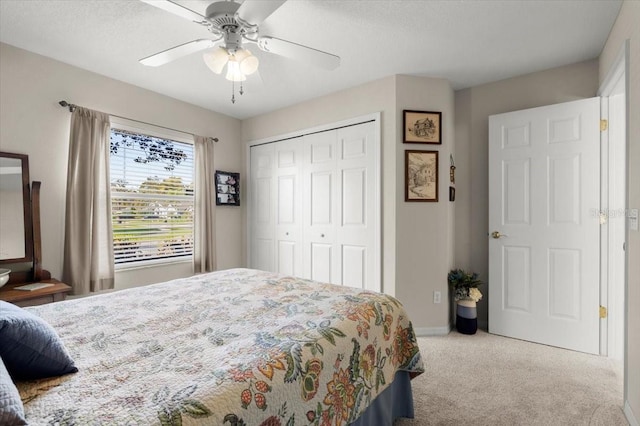 carpeted bedroom featuring a ceiling fan, a closet, and baseboards