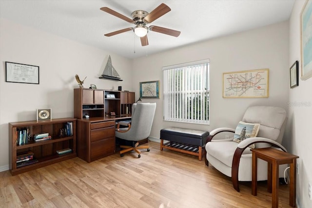 office area with light wood-style floors, baseboards, and ceiling fan