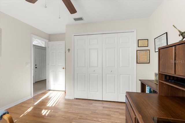 unfurnished bedroom featuring light wood-style flooring, baseboards, visible vents, and a closet