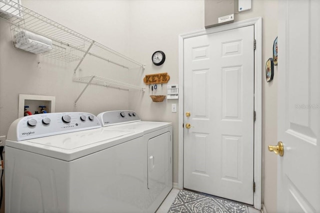 laundry room featuring light tile patterned floors, laundry area, and separate washer and dryer